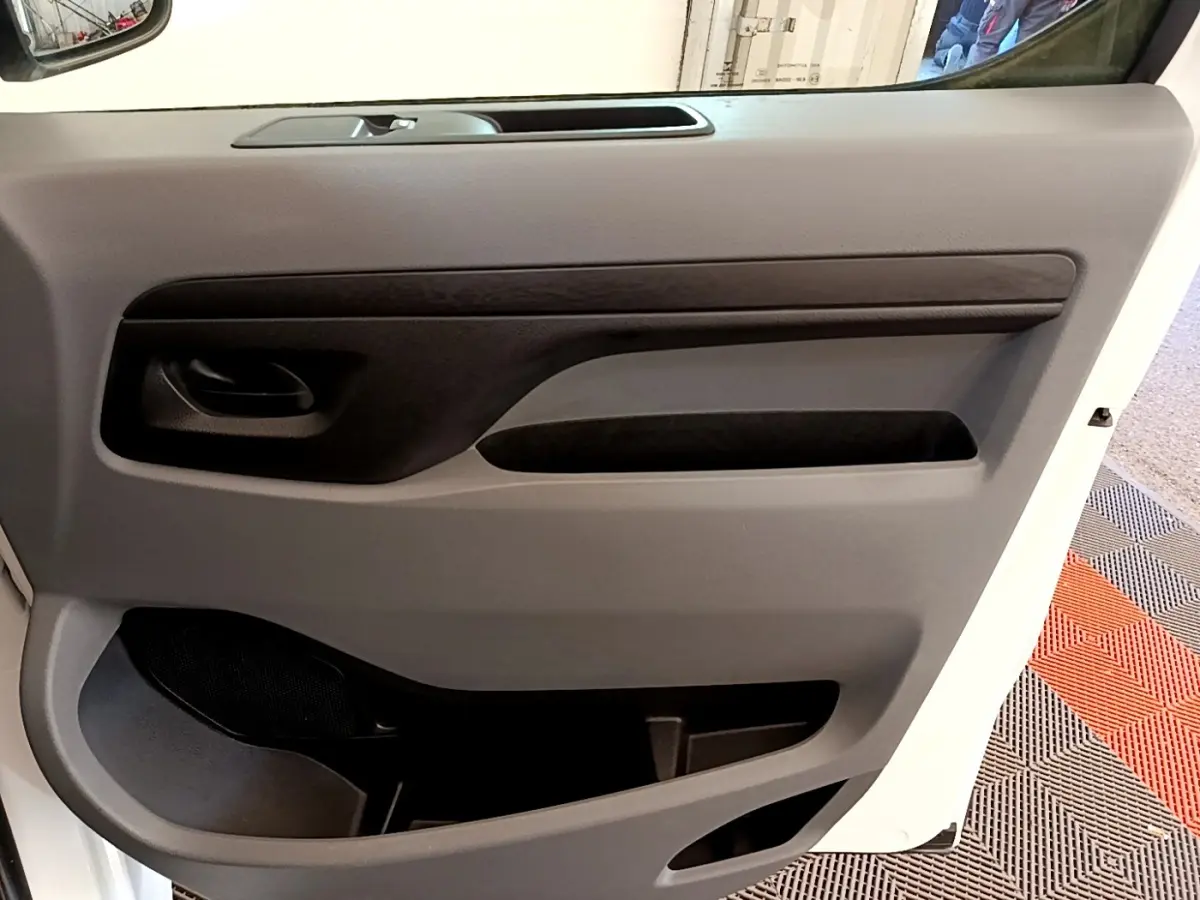 Vue rapprochée de la porte intérieure côté droit du Peugeot Traveller blanc 2018, avec poignée et rangements visibles.