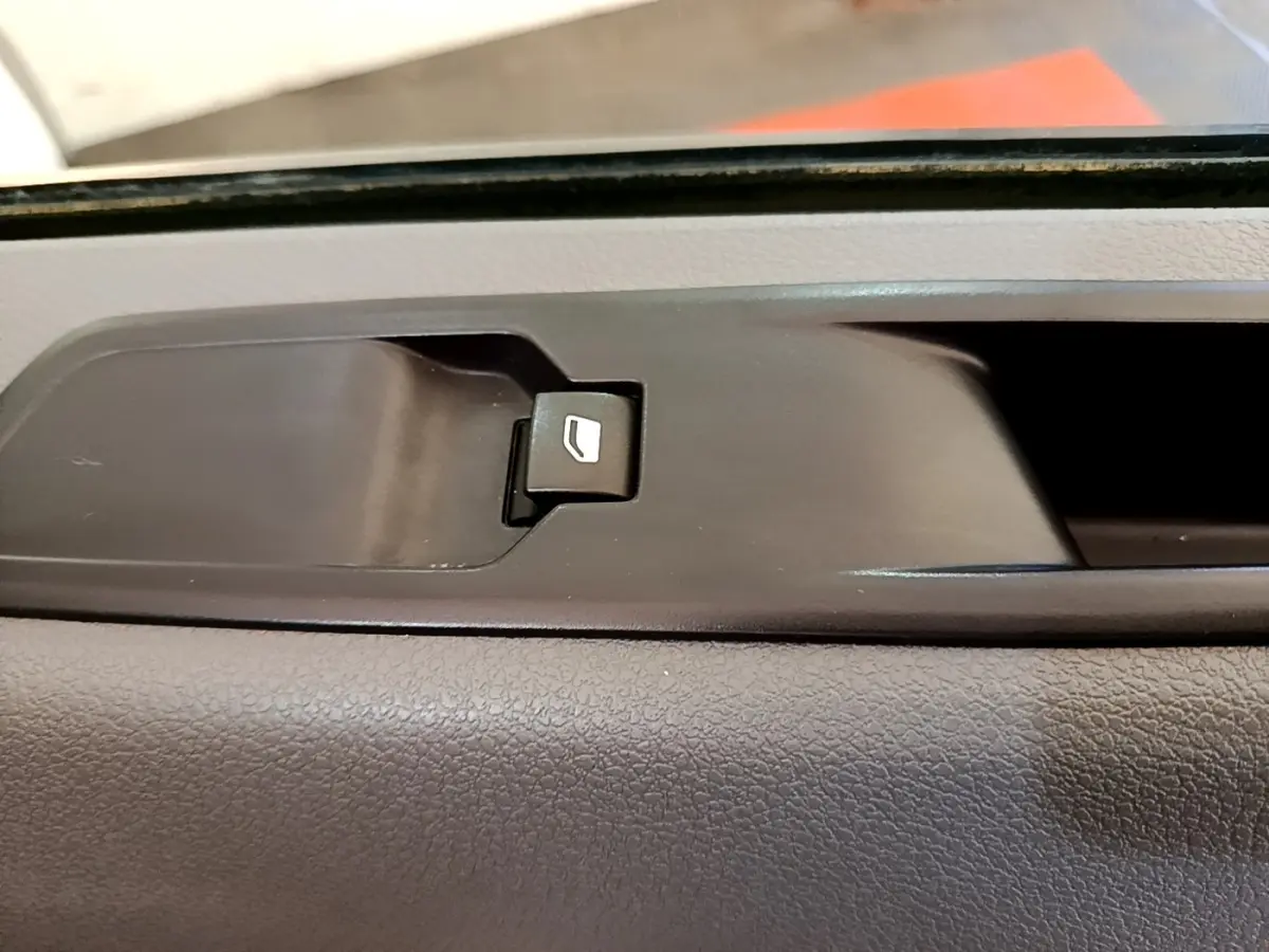 Gros plan sur le bouton de commande de la vitre côté intérieur d'une Peugeot Traveller blanc de 2018.