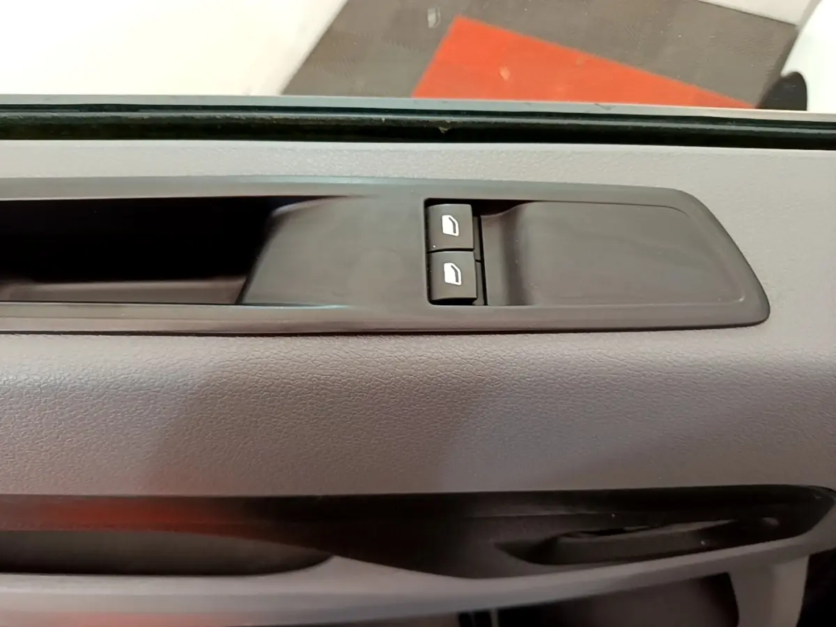Détail des commandes de lève-vitres sur la porte côté gauche d’un Peugeot Traveller blanc de 2018.