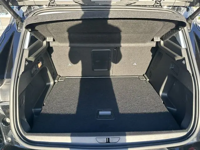 Coffre ouvert vu de l'arrière d'un Opel Grandland noir, espace de chargement vide et bien éclairé.