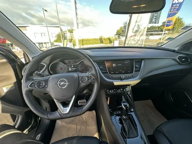 Vue intérieure de l'Opel Grandland noire 2020, tableau de bord et volant multifonction avec boîte automatique visible.