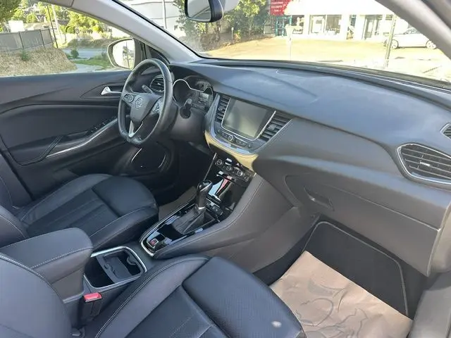 Vue intérieure côté conducteur de l’Opel Grandland noire de 2020, avec tableau de bord moderne et sièges en cuir noir.