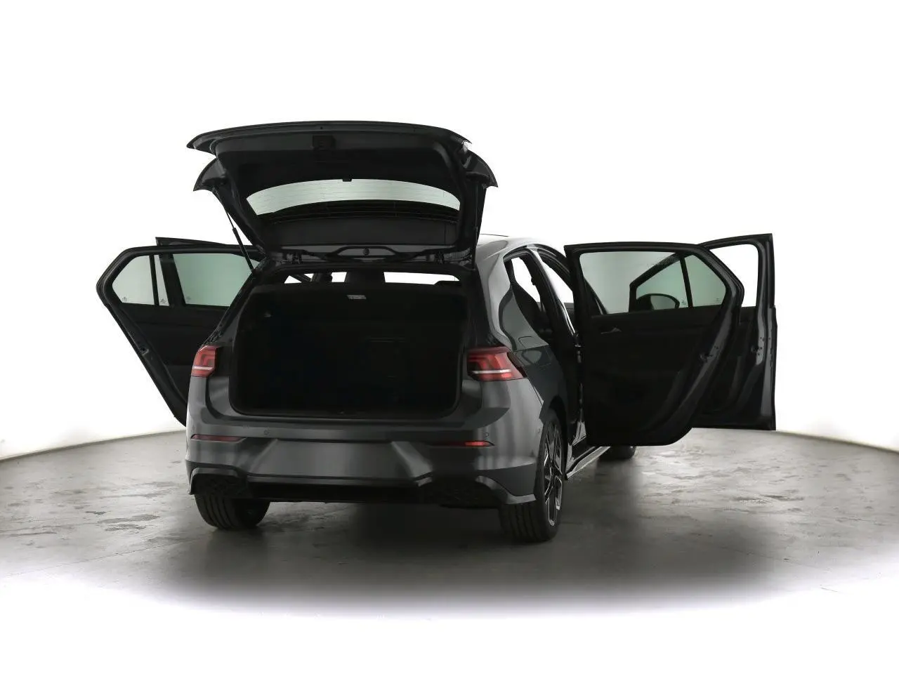 Volkswagen Golf VIII gris dauphin vue arrière avec portes et coffre ouverts, jantes alliage 18 pouces visibles.