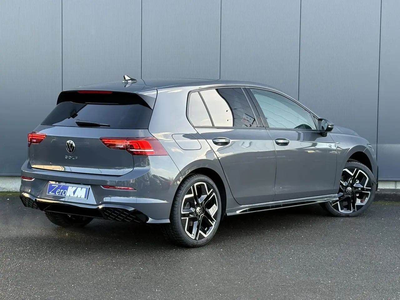 Volkswagen Golf VIII gris dauphin vue 3/4 arrière droit, jantes alliage 18" York et toit ouvrant panoramique.