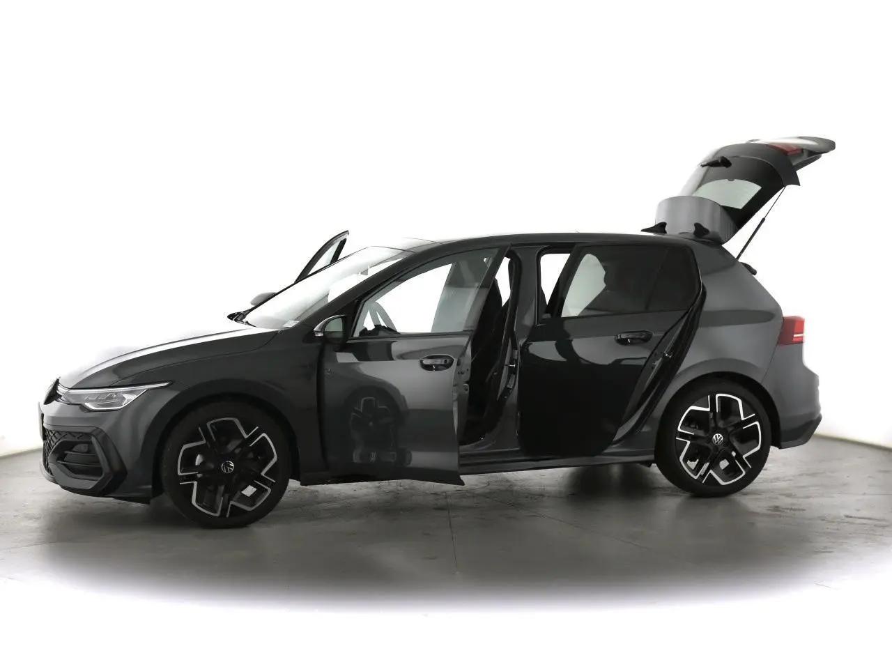 Volkswagen Golf VIII gris dauphin vue de profil gauche avec portes avant et arrière ouvertes et coffre relevé.