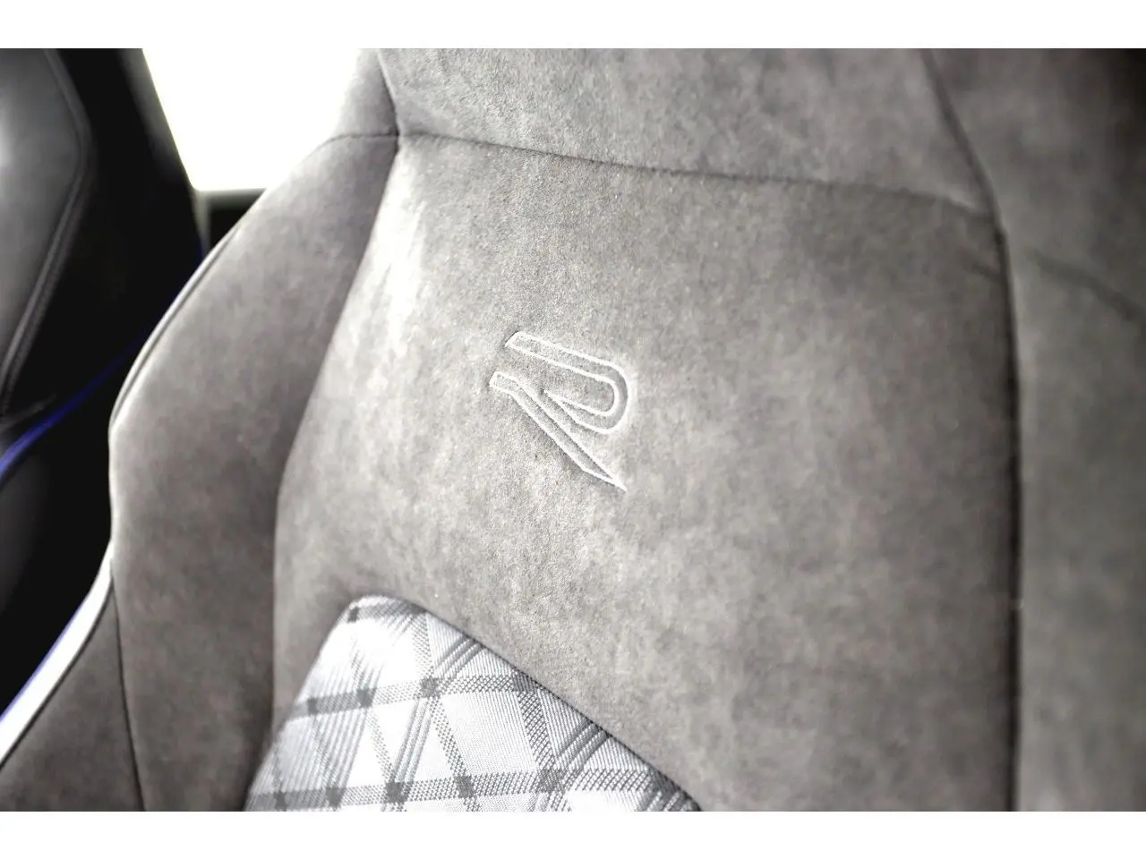 Gros plan sur le siège avant en alcantara gris avec logo R brodé, intérieur sportif de la Volkswagen Golf VIII R-Line.