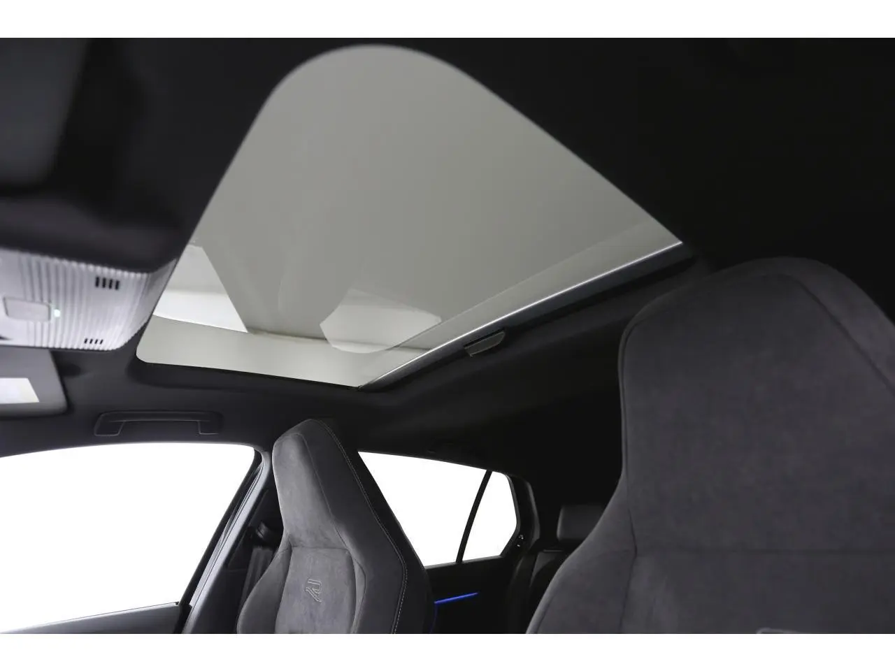 Vue intérieure montrant le toit ouvrant panoramique et les sièges sport R-Line en tissu gris foncé de la Volkswagen Golf VIII.