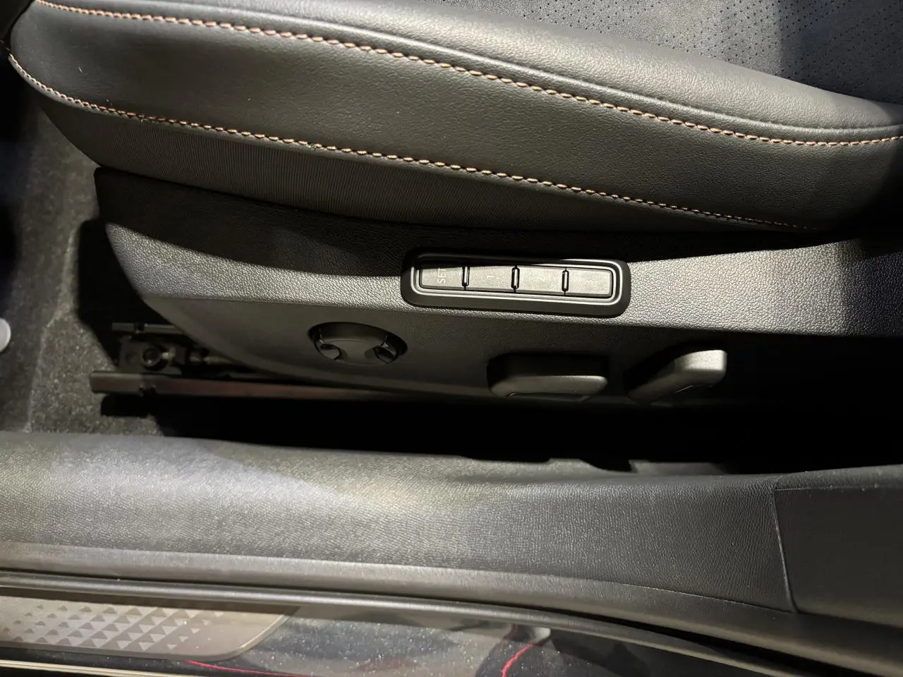 Détail des commandes de réglage électrique du siège conducteur noir avec surpiqûres cuivrées sur la CUPRA Leon.