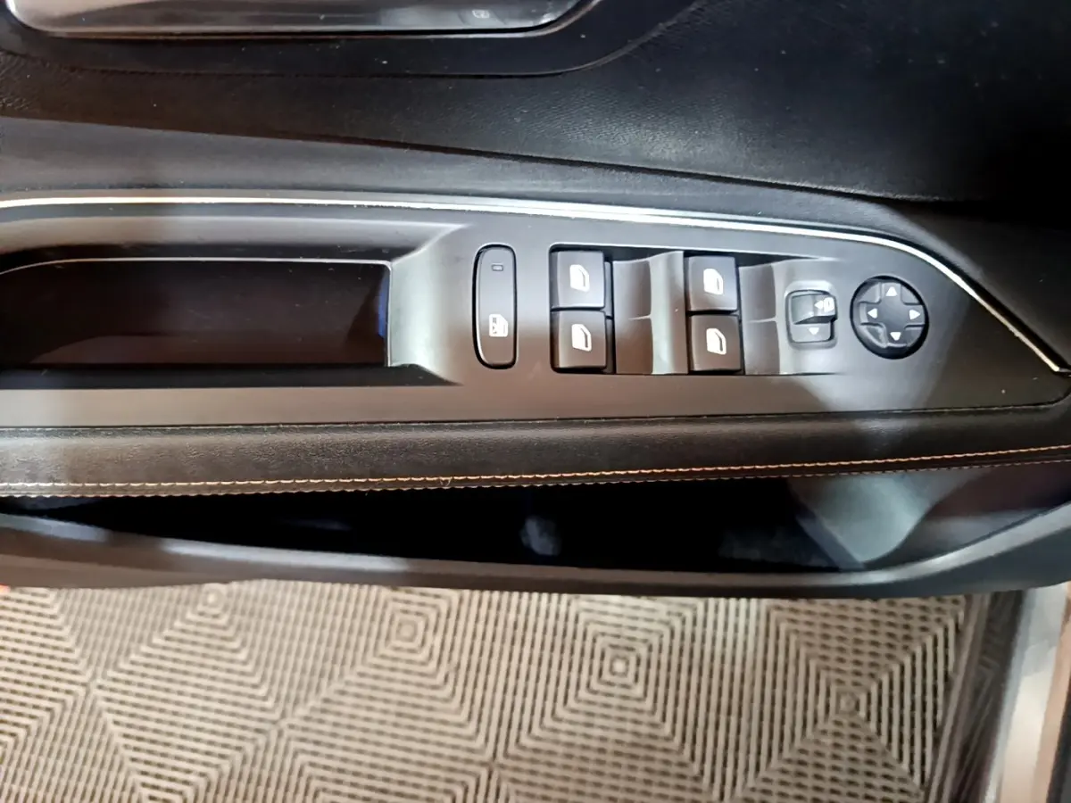 Gros plan sur la commande des vitres et rétroviseurs côté conducteur du Peugeot 3008 GT Line gris foncé.