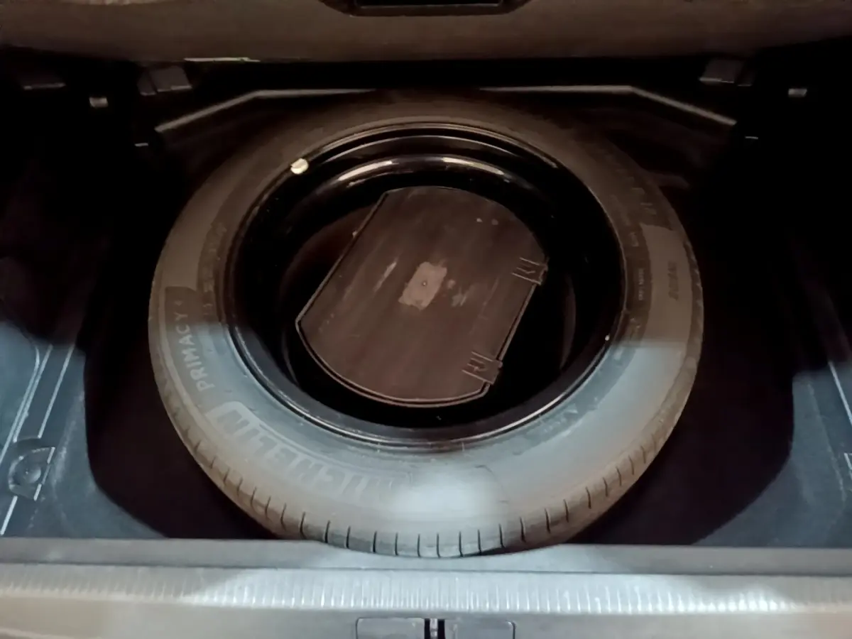 Vue rapprochée de la roue de secours noire dans le coffre du Peugeot 3008 gris foncé, version GT Line 2020.