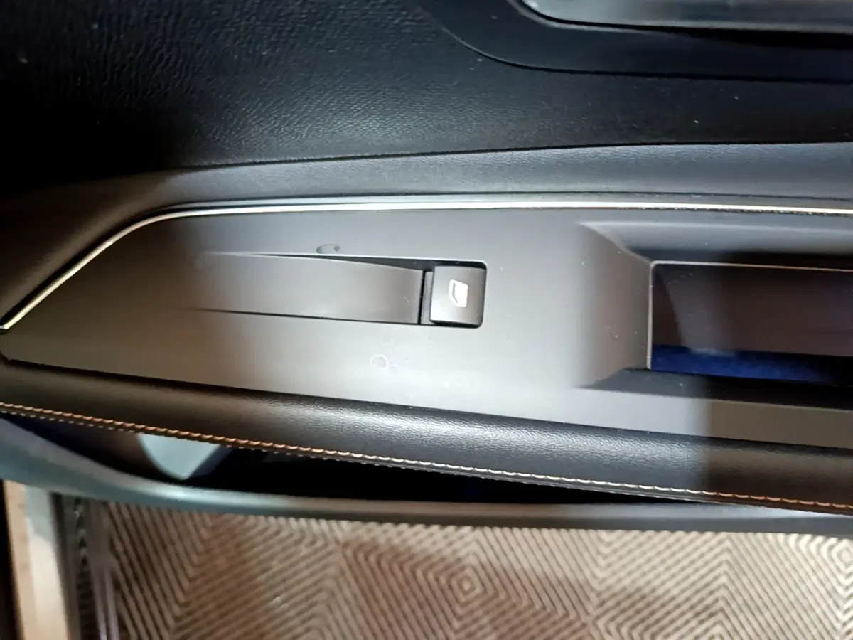 Détail de la commande électrique de frein à main sur la console centrale noire du Peugeot 3008 GT Line gris foncé.