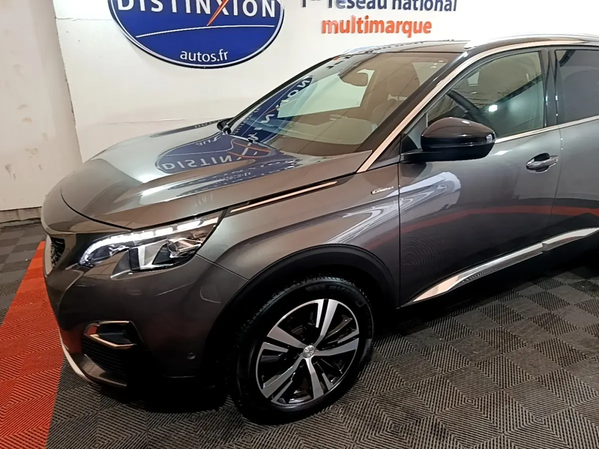 Vue 3/4 avant droit d’un Peugeot 3008 gris foncé avec phares LED et jantes alliage distinctives.