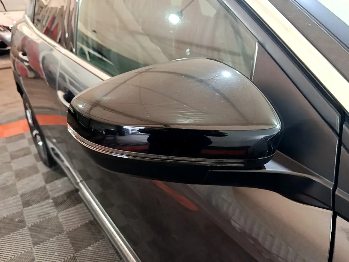Gros plan sur le rétroviseur côté gauche du Peugeot 3008 gris foncé, avec clignotant intégré et carrosserie brillante.
