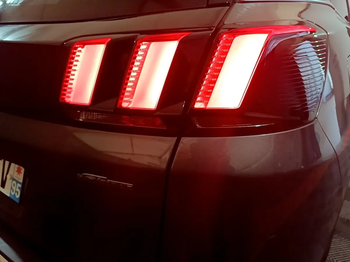 Feux arrière allumés en gros plan sur le côté droit d’un Peugeot 3008 GT Line gris foncé de 2020.