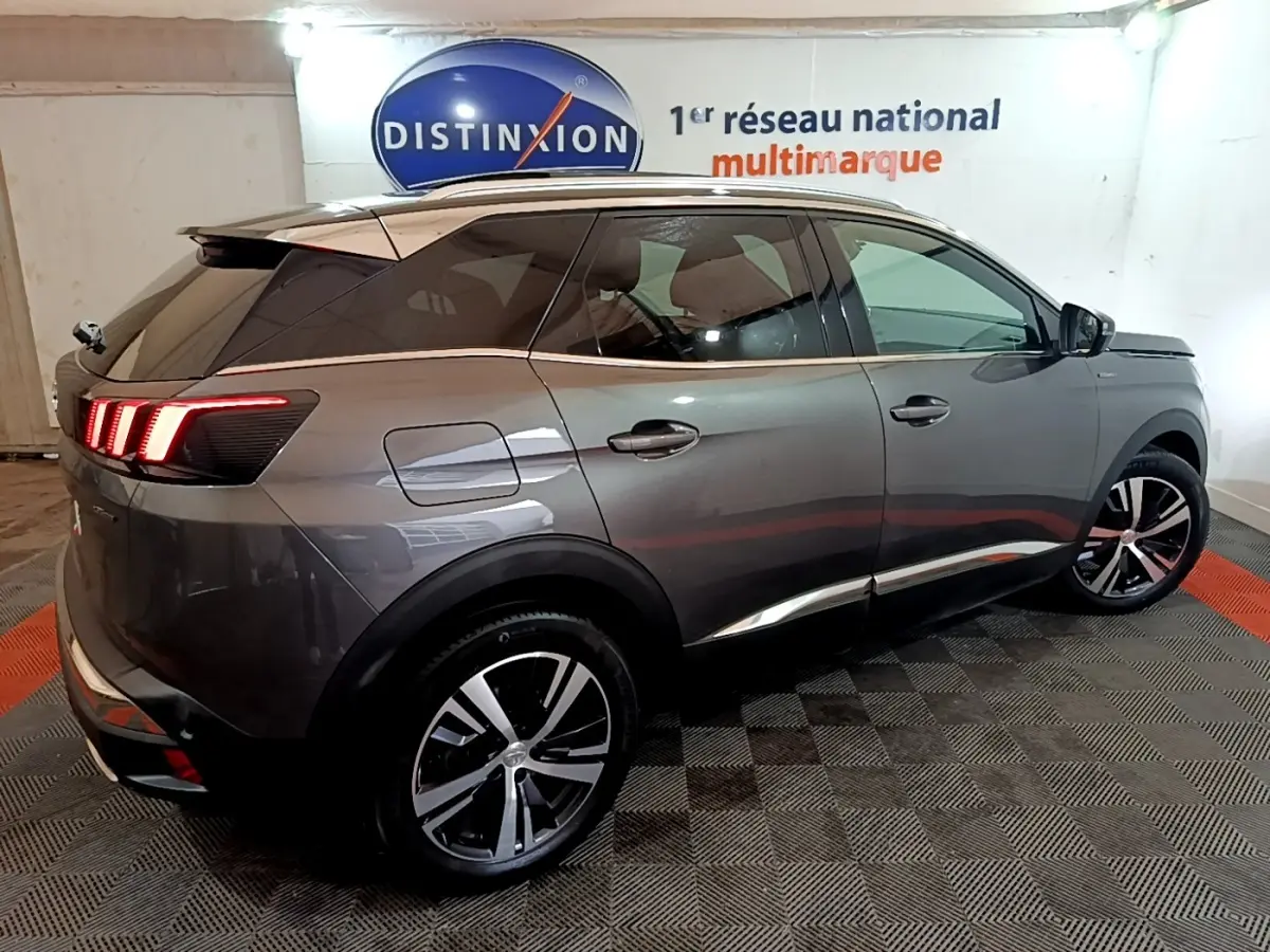Peugeot 3008 GT Line gris foncé vue 3/4 arrière droit, feux arrière LED allumés, jantes alliage distinctives.