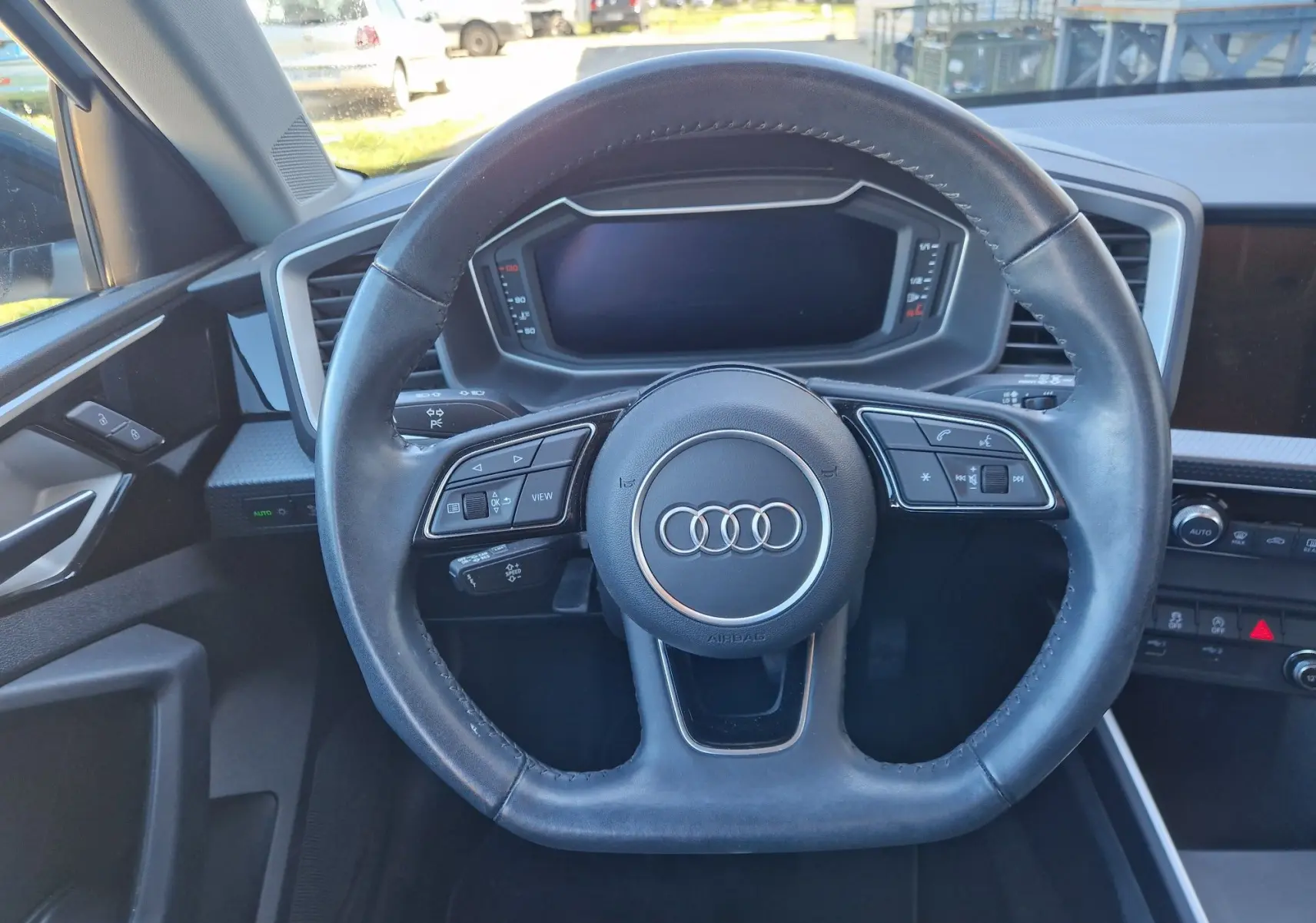 Vue intérieure centrée sur le volant cuir de l'Audi A1 Sportback 2020 avec tableau de bord numérique éteint.