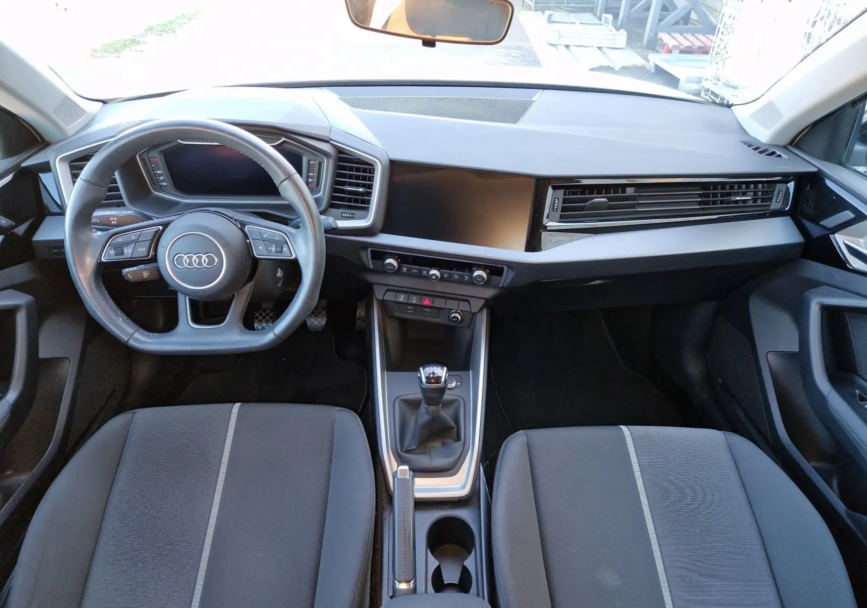 Vue intérieure de l'Audi A1 Sportback 2020 montrant le tableau de bord, volant multifonction et levier de vitesses manuel.