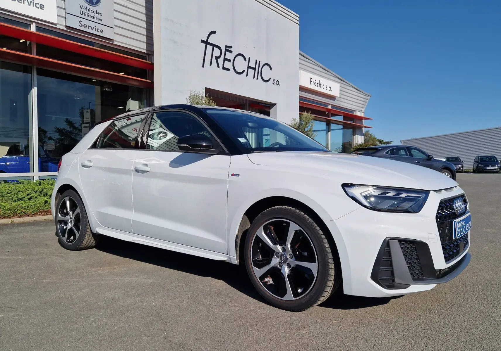 Audi A1 Sportback blanc glacier vue 3/4 avant droit, avec jantes alliage noires et toit noir contrasté.