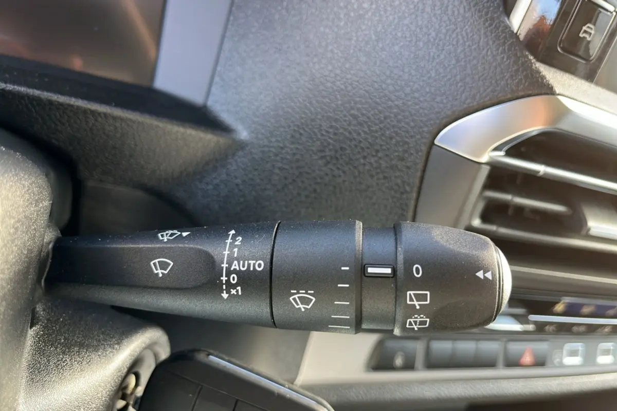 Gros plan sur la commande des essuie-glaces du Peugeot Traveller 2025, intérieur noir avec détails argentés.