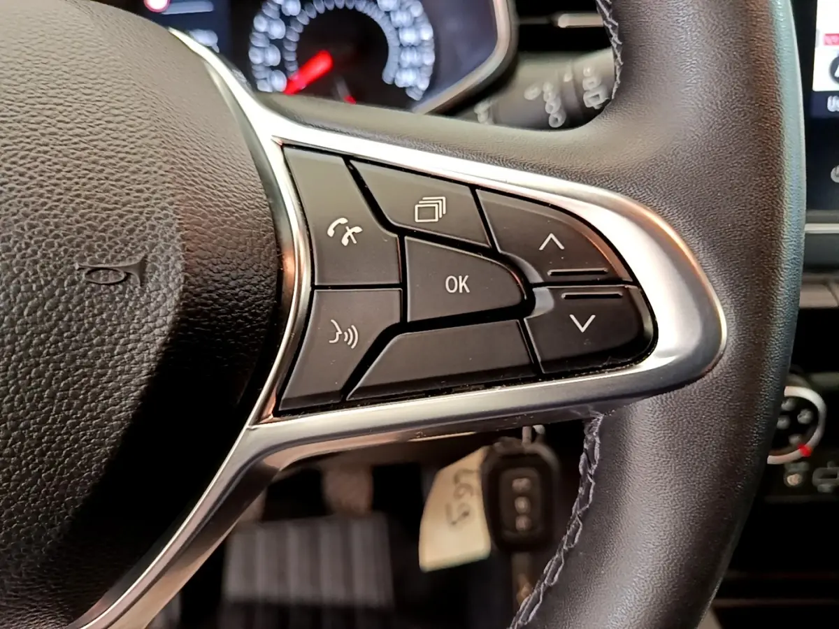 Gros plan sur les commandes multifonctions à droite du volant noir du Renault Clio Business Blue dCi 85 blanc de 2020.