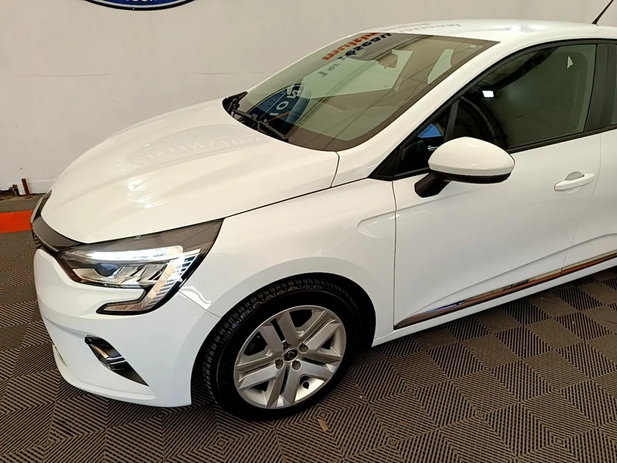 Vue 3/4 avant droit d'une Renault Clio Business Blue dCi 85 blanche avec jantes alliage et feux LED allumés.