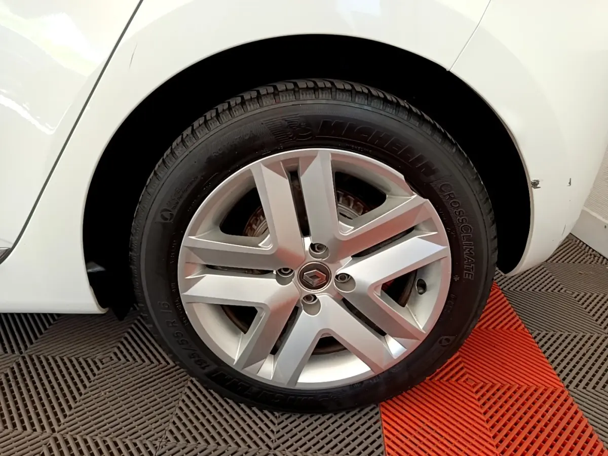 Gros plan sur la roue arrière droite d'une Renault Clio Business Blue dCi 85 blanche avec une rayure visible sur l'aile.