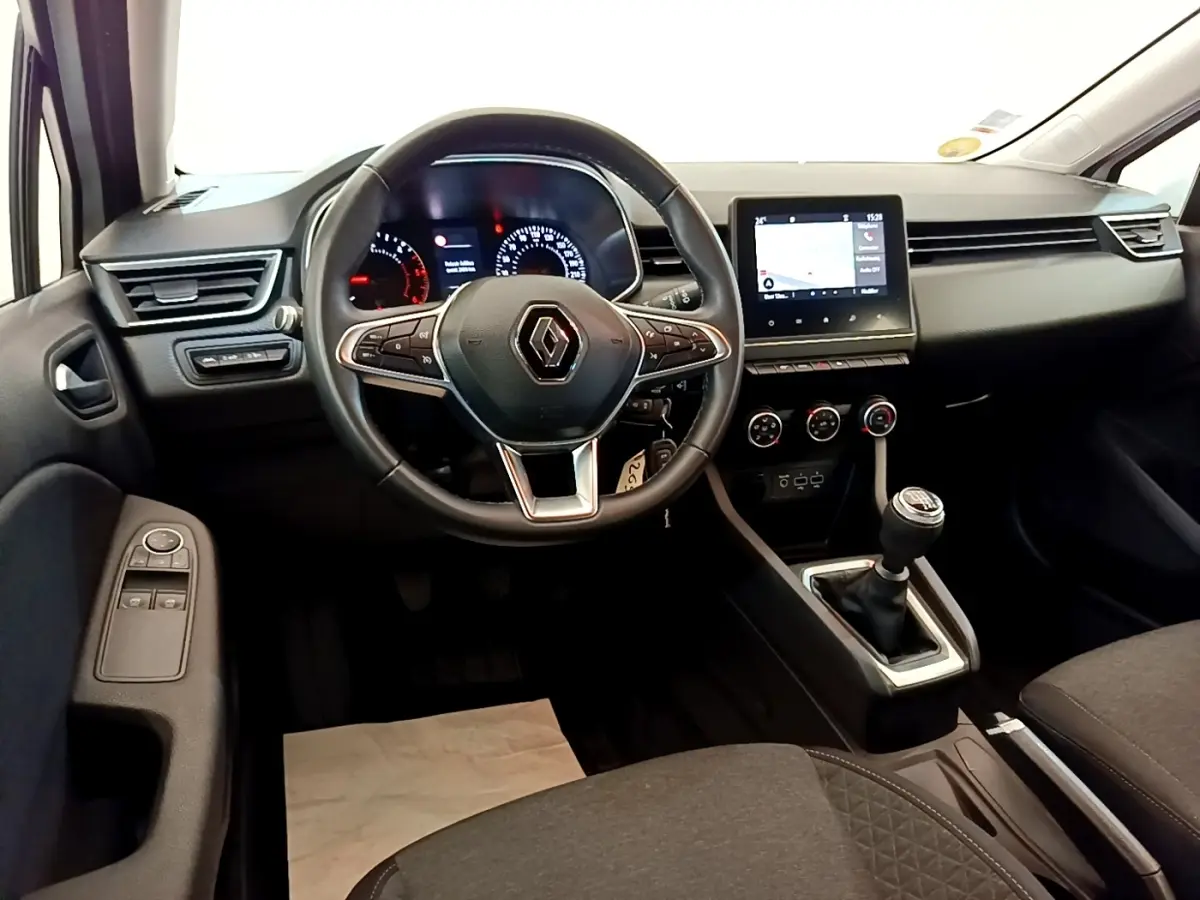 Vue intérieure avant du tableau de bord noir de la Renault Clio Business Blue dCi 85 avec volant multifonction et écran tactile central.