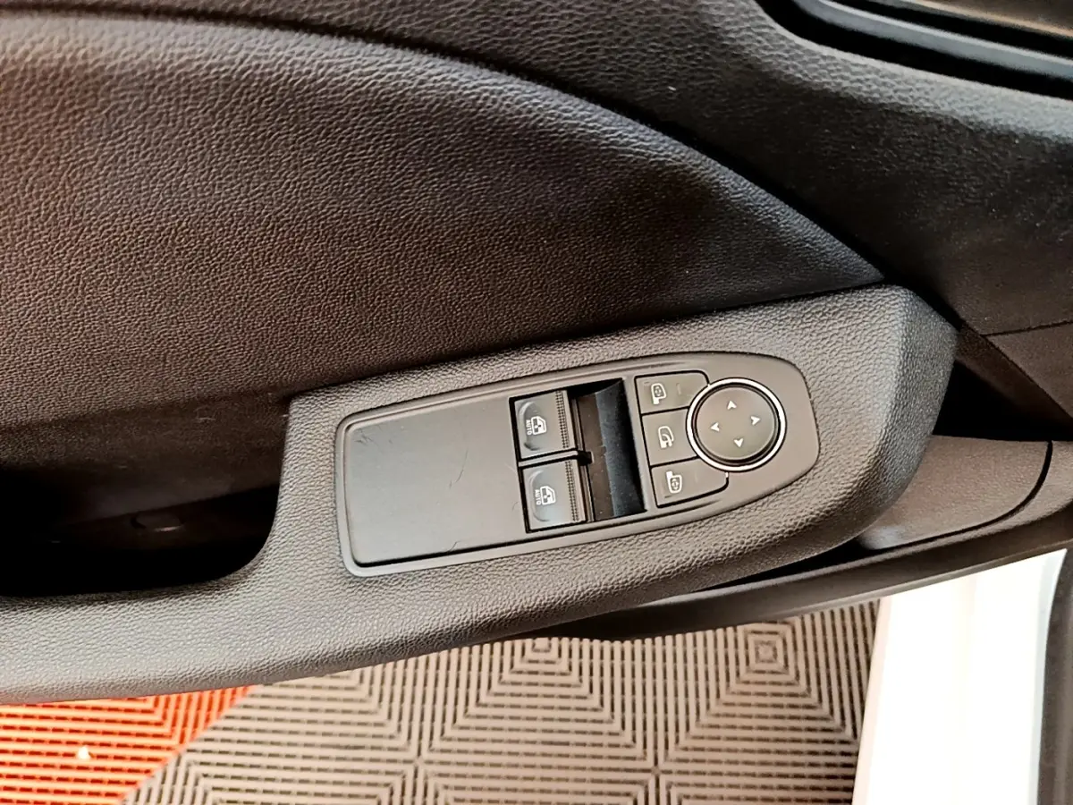 Commande des vitres électriques et réglage des rétroviseurs sur la porte côté conducteur d'une Renault Clio blanche 2020.