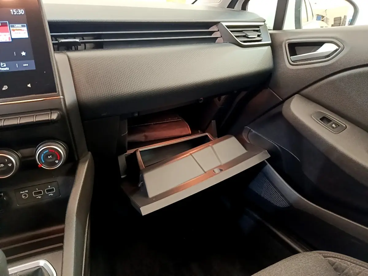 Vue intérieure côté passager de la Renault Clio Business Blue dCi 85 2020, boîte à gants ouverte et tableau de bord noir.
