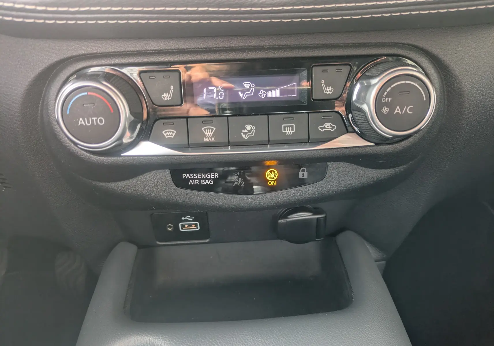 Tableau de bord du Nissan Juke 2020, vue centrée sur la console de climatisation avec affichage digital et boutons noirs.