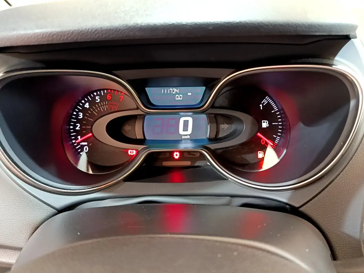Vue rapprochée du tableau de bord numérique du Renault Captur gris foncé, affichant 0 km/h et jauge essence basse.