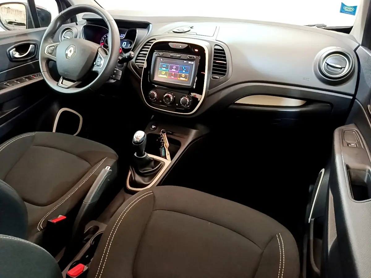 Vue intérieure avant du Renault Captur Business avec tableau de bord noir, écran tactile 7 pouces et boîte manuelle.