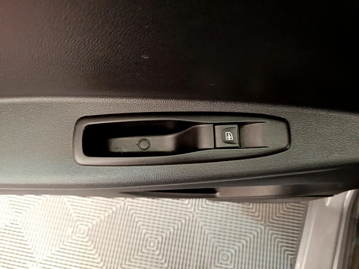 Bouton de commande de lève-vitre côté conducteur sur la porte intérieure noire du Renault Captur gris foncé 2018.