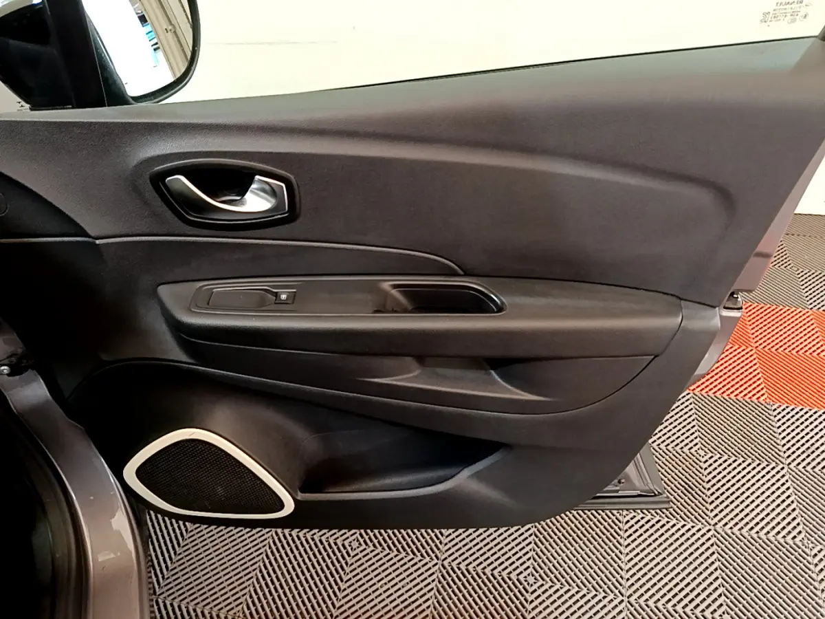 Vue rapprochée de la porte côté conducteur du Renault Captur gris foncé, avec poignée intérieure et haut-parleur intégré.