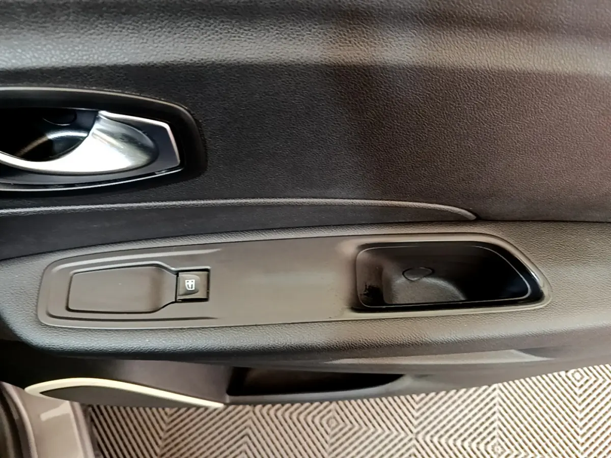 Poignée intérieure côté gauche de porte Renault Captur Business gris foncé avec bouton de commande de vitre électrique.