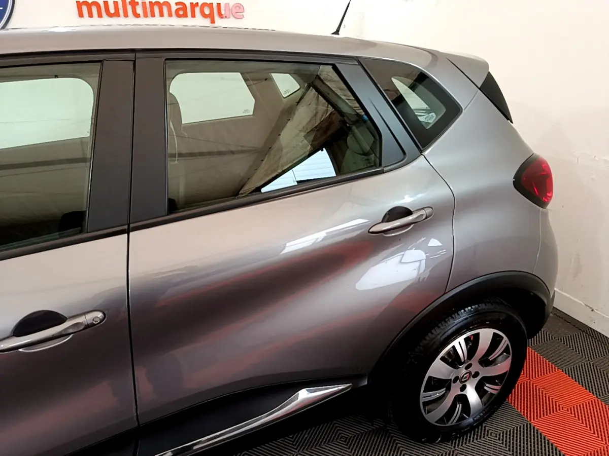 Vue latérale côté droit du Renault Captur gris foncé 2018, mettant en valeur la porte arrière et la roue arrière.