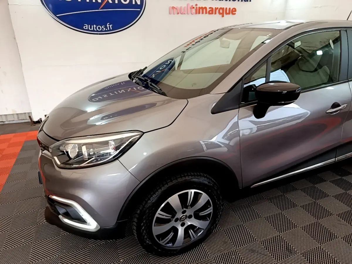 Vue 3/4 avant droit d'un Renault Captur gris foncé avec phares LED et jantes alliage distinctives.
