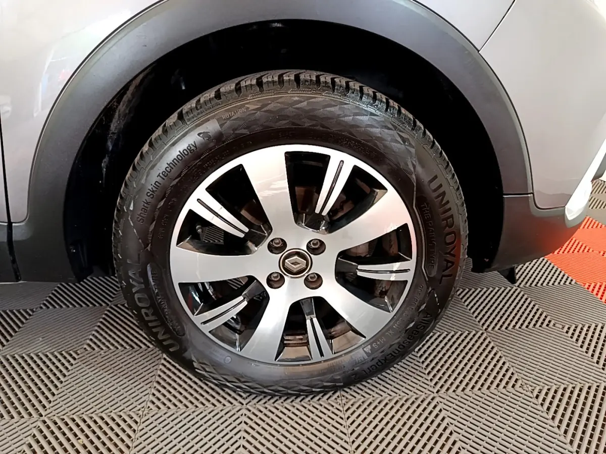 Gros plan sur la roue avant droite d’un Renault Captur gris foncé avec jante alliage et pneu Uniroyal.