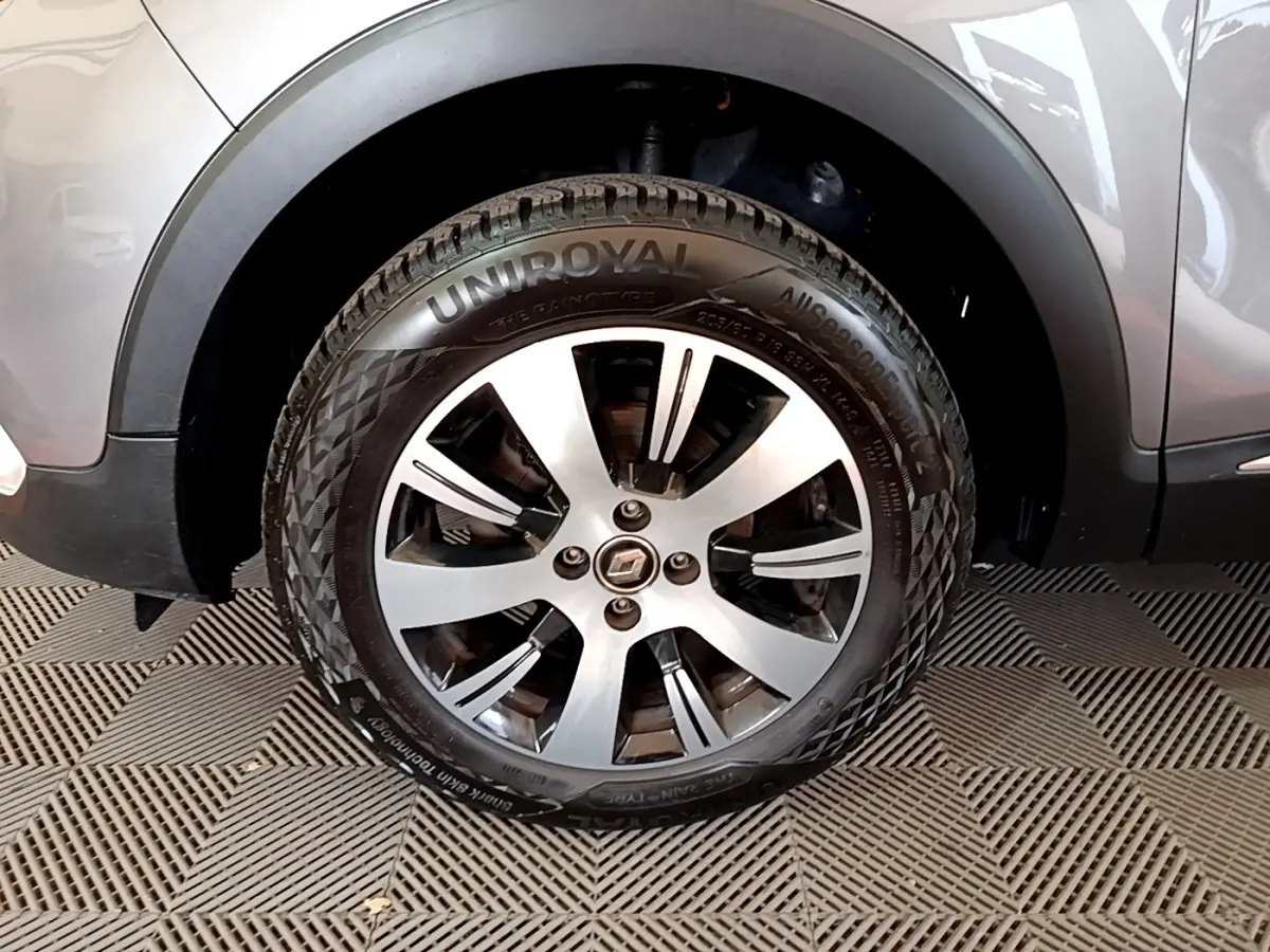 Gros plan sur la roue avant gauche d’un Renault Captur gris foncé, mettant en valeur la jante alliage et le pneu Uniroyal.