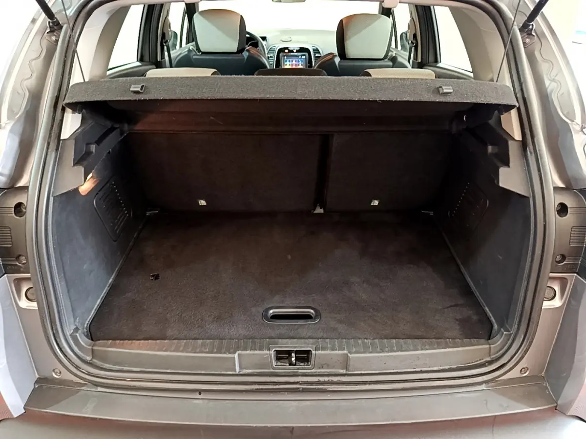 Coffre ouvert d'un Renault Captur gris foncé vu de l'arrière, montrant la banquette arrière et la tablette cache-bagages.