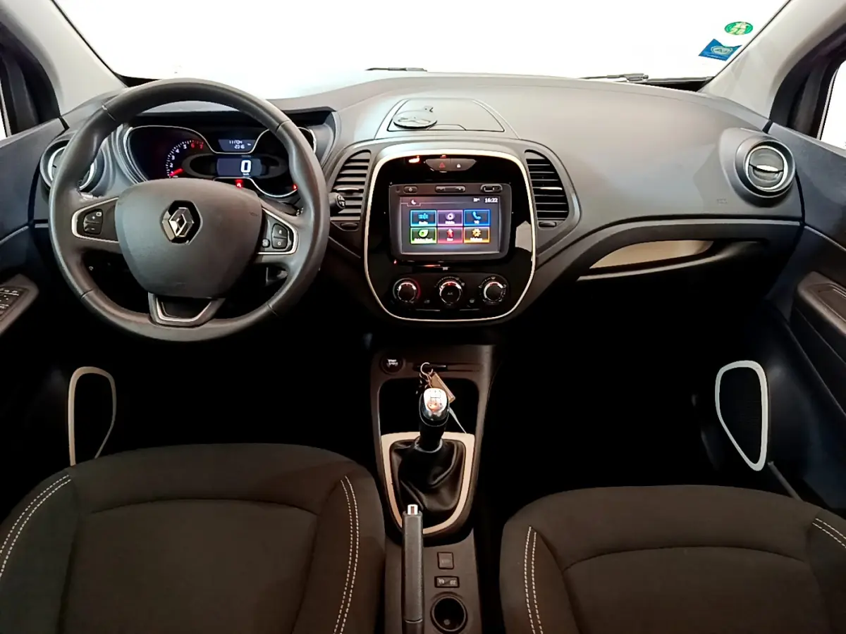 Vue frontale de l'habitacle du Renault Captur gris foncé 2018 avec volant cuir, écran tactile 7 pouces et boîte manuelle.