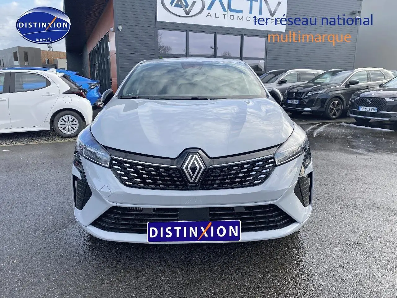 Renault Clio V gris rafale vue de face, calandre noire avec logo Renault et phares LED fins.
