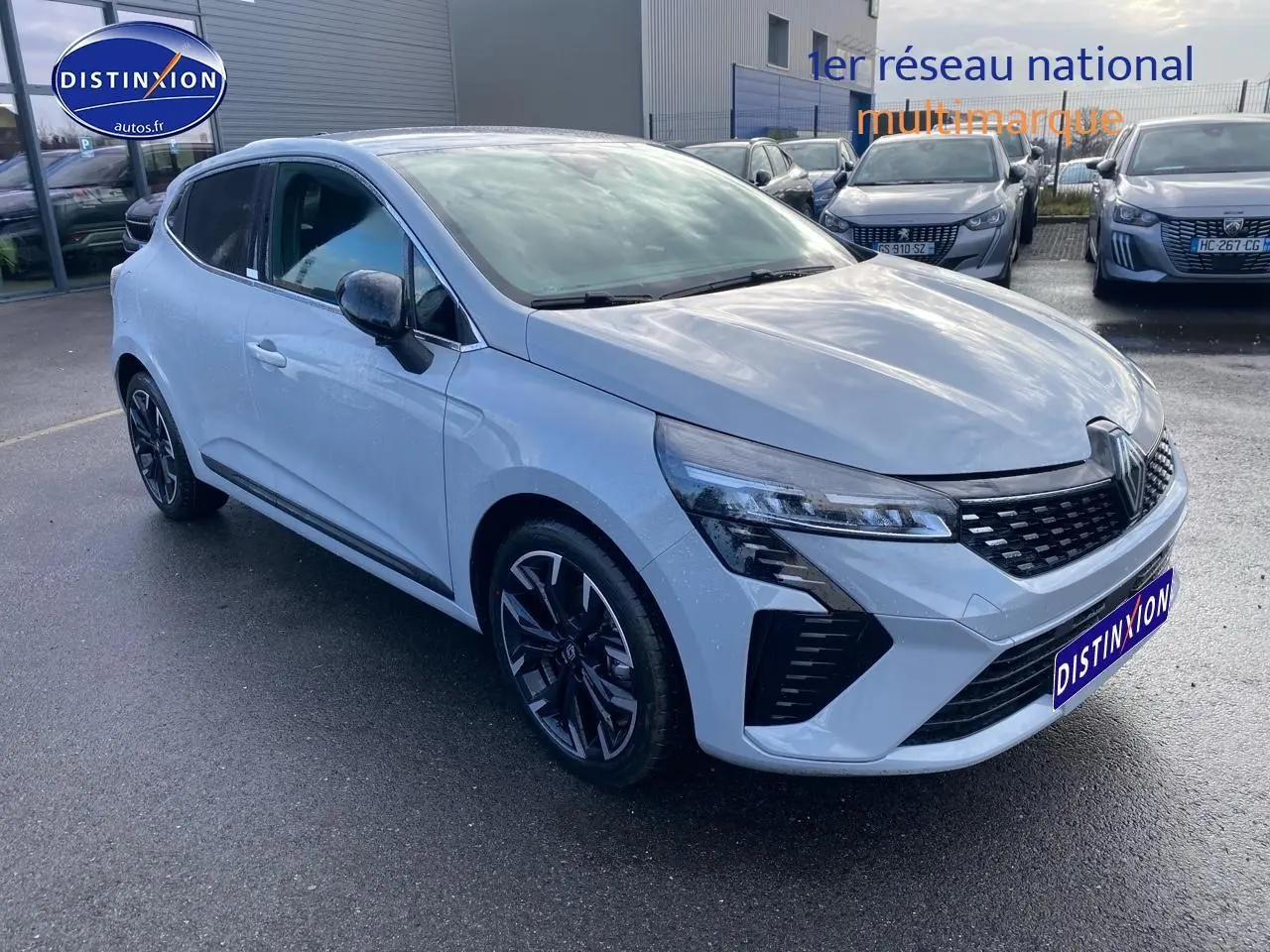 Renault Clio V gris rafale vue 3/4 avant droit avec calandre chromée et jantes alu noires.