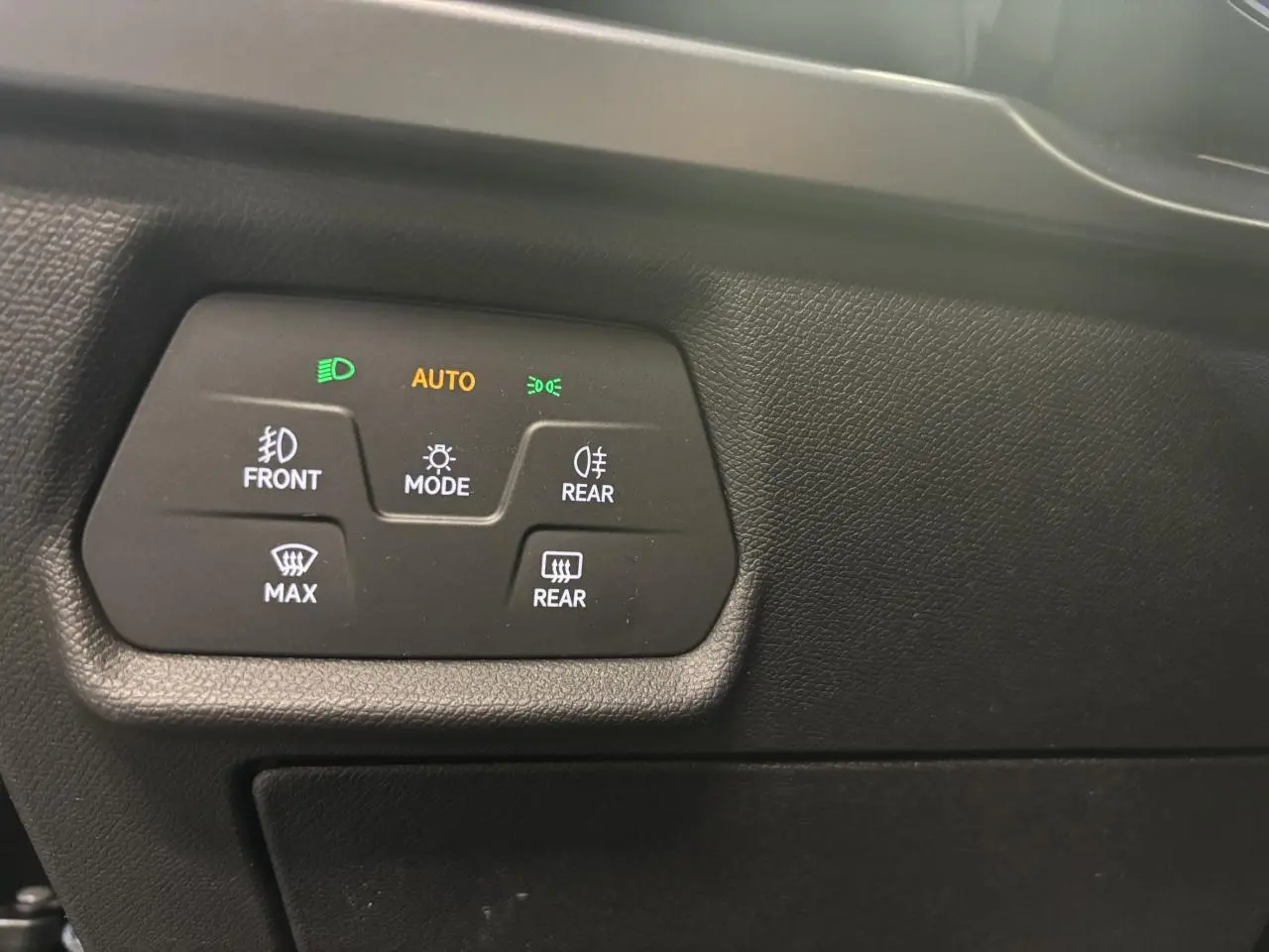 Détail du tableau de bord noir texturé avec commandes d’éclairage et de désembuage sur CUPRA Leon Bleu Fjord.