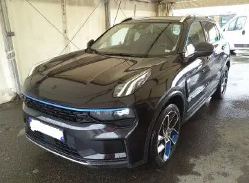 Vue 3/4 avant d’un SUV Lynk & Co 01 PHEV noir avec jantes alliage 20’’ et détails bleus sur calandre et roues.