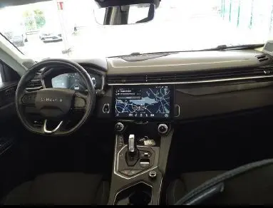 Vue intérieure du tableau de bord et console centrale noire du LYNK & CO 01 PHEV 261 DCTH avec écran tactile et volant multifonctions.