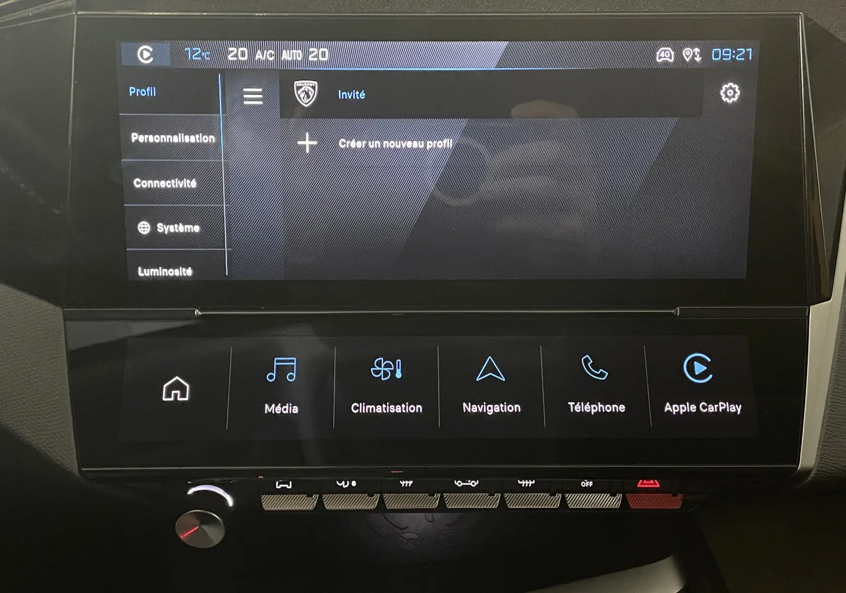 Écran tactile central du tableau de bord de la Peugeot 308 Hybrid 145, affichant les menus profils et climatisation.