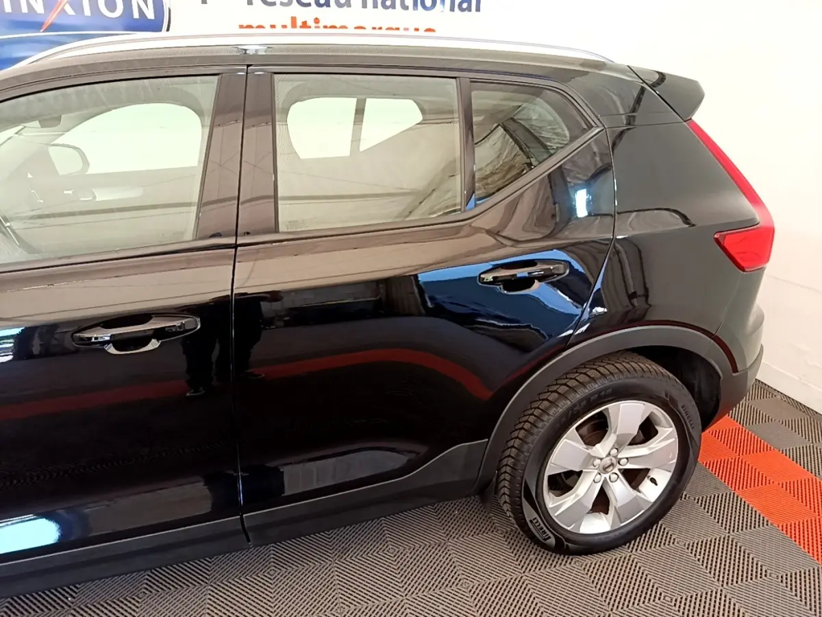 Vue latérale côté droit du Volvo XC40 T2 noir, mettant en valeur les jantes alliage et la ligne de toit avec spoiler.