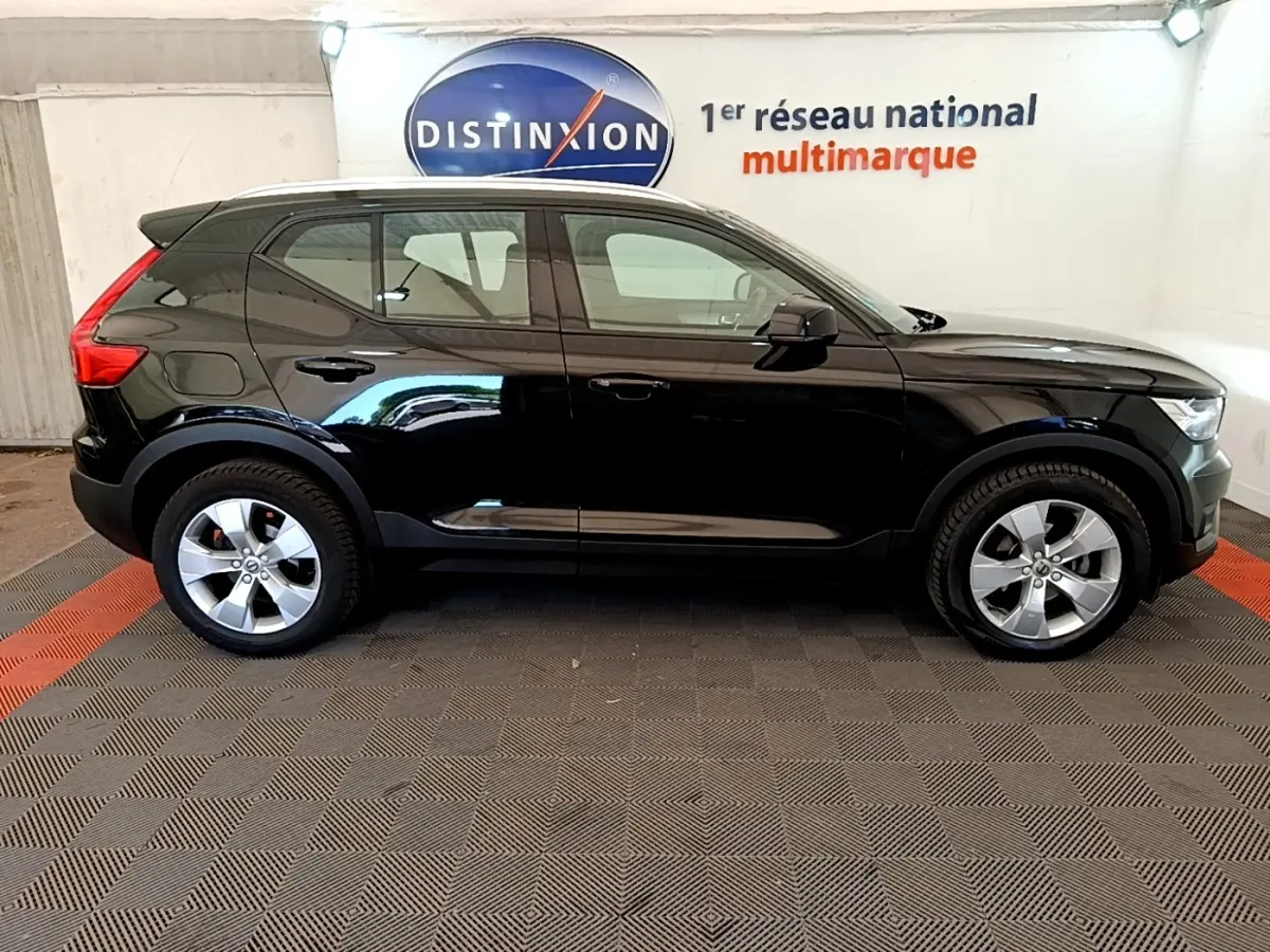 Profil droit du Volvo XC40 T2 noir 2020 garé en intérieur avec jantes argentées et toit noir.