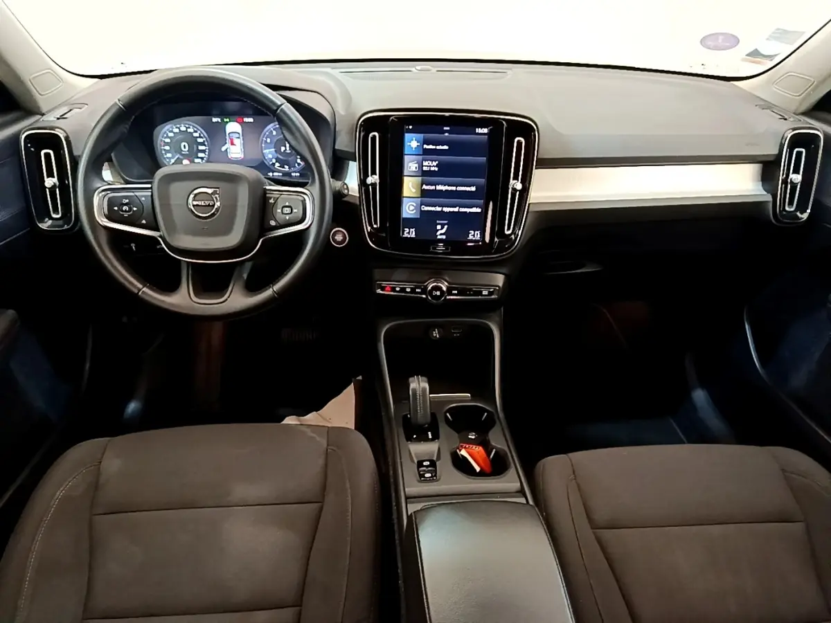 Vue intérieure avant du tableau de bord noir du Volvo XC40 T2 2020 avec écran tactile central et volant multifonctions.